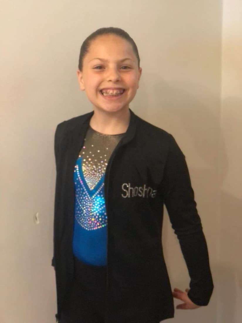 A young gymnast in a competition leotard